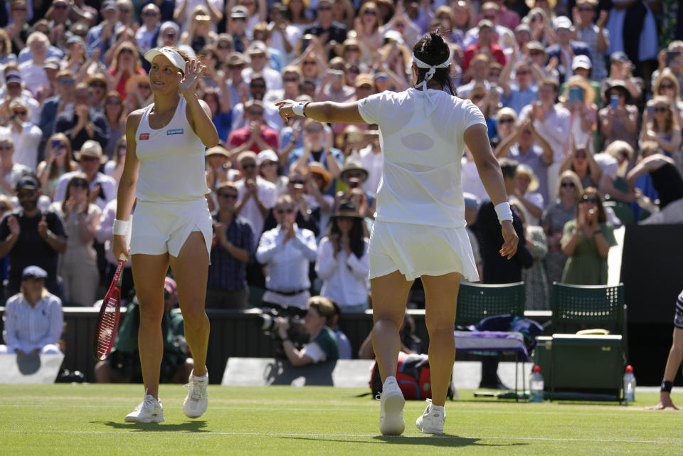 Tunisia's Ons Jabeur, right, gestures to Germany's Tatjana Maria to receive applause from the crowd after beating her in a women's singles semifinal match on day eleven of the Wimbledon tennis championships in London, Thursday, July 7, 2022. (AP Photo/Kirsty Wigglesworth)