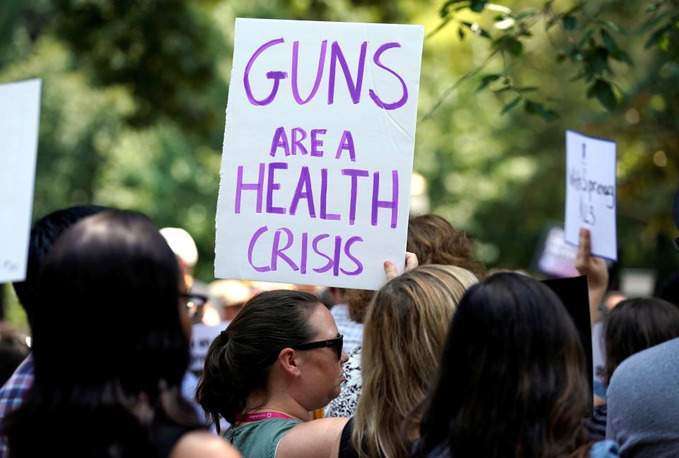 FILE PHOTO: A woman holds a sign during a rally against guns and white supremacy in the wake of mass shootings in Dayton and El Paso in front of the White House in Washington, U.S., August 6, 2019.  REUTERS/Kevin Lamarque/File Photo