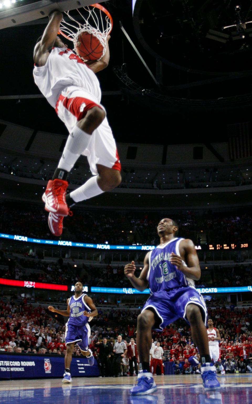 Wisconsin forward Alando Tucker hangs on to the basket after dunking the ball while Texas A&M Corpus Christi's Josh Ervin (12) watches during the second half of their Midwest Regional NCAA first round basketball game in Chicago, Friday, March 16, 2007.