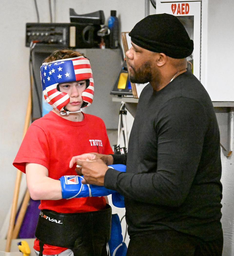 Thomas "Truth" Hardy has his gloves laced by coach Jesse Barboza. Hardy, a Barnstable High School freshman, won the New England Silver Gloves competition in his weight class and advanced to the National Silver Gloves competition.