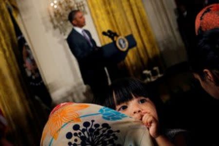 Sophia Ahmadinejad, 2-year-old, a refugee from Afghanistan listens as U.S. President Barack Obama delivers remarks at an Eid al-Fitr reception at the White House in Washington, U.S., July 21, 2016. REUTERS/Carlos Barria