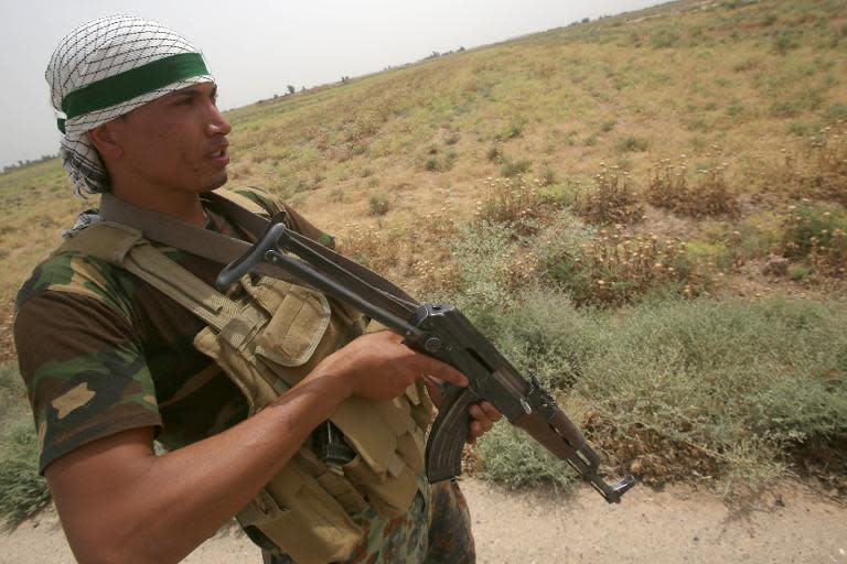 An Iraqi pro-government militiaman holds a position on a road after the liberation from Islamic State militants of the village of Sayed Ghareeb, near Dujail, some 70 kilometres north of Baghdad on June 2, 2015