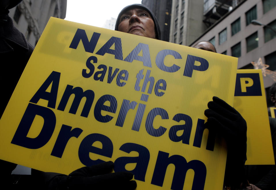 Mary Collie of the NAACP listens to a speaker at a rally calling for an end to predatory lending practices and home foreclosures outside the New York Stock Exchange December 10, 2007.  REUTERS/Jeff Zelevansky (UNITED STATES)