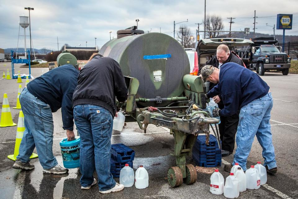 Local residents in Charleston, W.V. continue to arrive at distribution centers to load up on bottled water Sunday, Jan. 12, 2014 after a chemical spill Thursday in the Elk River that has contaminated the public water supply in nine counties. Frustration is mounting for many of the 300,000 West Virginia residents who've gone three days without clean tap water. (AP Photo/Michael Switzer)