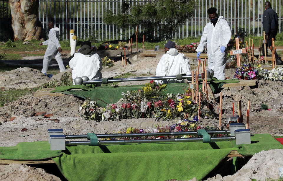 Funeral workers in personal protective equipment prepare a grave for a burial in the COVID-19 section of the Maitland Cemetary in Cape Town, South Africa, Wednesday, July 15, 2020. For months, the city of Cape Town was the biggest coronavirus hot spot in Africa. Now, finally, there are signs of relief. (AP Photo/Nardus Engelbrecht)