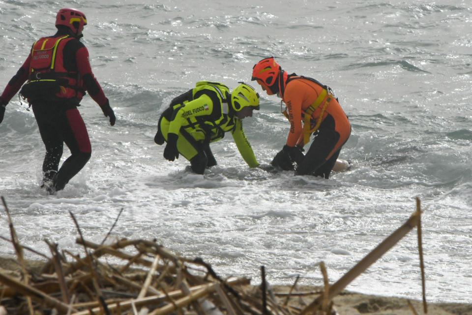 Rescuers recover a body after a migrant boat broke apart in rough seas, at a beach near Cutro, southern Italy, Sunday, Feb. 26, 2023.  / Credit: Giuseppe Pipita / AP