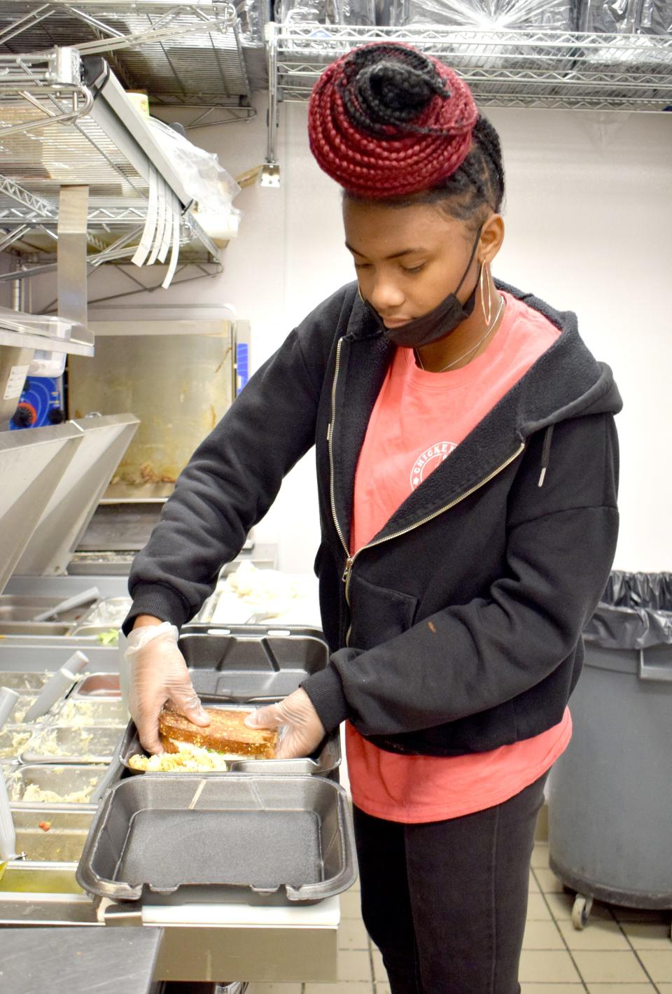 Niyah Mitchell, sandwich line worker for Chicken Salad Chick in Panama City, prepares a customer's food on Thursday. The business is among those that have experienced a recent uptick in applications leading up to the holiday season.