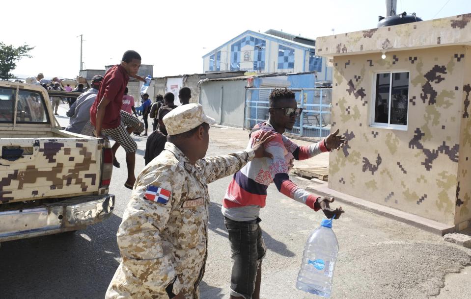 A Dominican Republic security officer checks a man crossing the border bridge between Dajabón, Dominican Republic, and Haiti, Thursday, Sept. 14, 2023. The president of the Dominican Republic announced Thursday that he would close all borders with neighboring Haiti starting Friday in response to the construction of a supposed canal on Haitian soil that targets waters from the Massacre River, which runs along the border shared by both countries. (AP Photo/Ricardo Hernández)