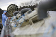 FILE - In this March 6, 2015, file photo, a worker of Yagisawa Shoten Co., checks soy sauce tanks of the company's new factory in Ichinoseki, Iwate Prefecture, northeastern Japan. Just a month after a tsunami as high as 17 meters (55 feet) smashed into the city of Rikuzentakata, soy sauce maker Michihiro Kono inherited his family's two-century-old business from his father. Later this year the ninth generation owner of Yagisawa Shoten Co. will open a new factory on the same ground where his family started making soy sauce in 1807. (AP Photo/Eugene Hoshiko)