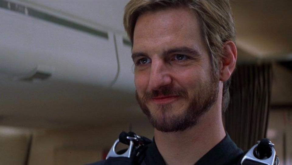 A man with a beard smiles in Mission: Impossible II