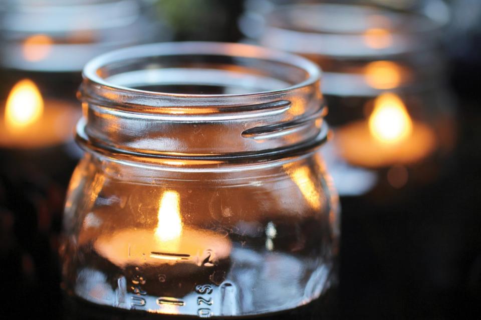 Lighted tea candles floating in canning jars.