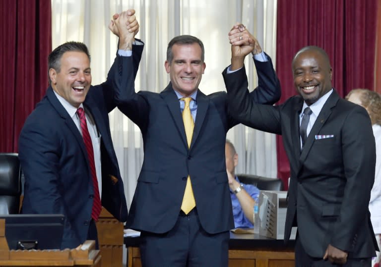 Los Angeles mayor Eric Garcetti (C) celebrates with city councilmen Joe Buscaino (L) and Marqueece Harris-Dawson after the council voted to bid for the 2024 Summer Olympics, at the City Hall, on September 1, 2015