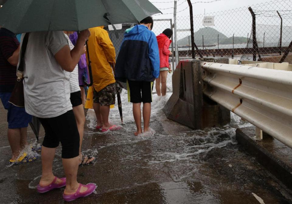 The tropical cyclone warning was lowered to a 3 from an 8 by the Hong Kong Observatory on Tuesday afternoon. Some of the bus and tram services have resumed.  (Photo by: Associated Press)