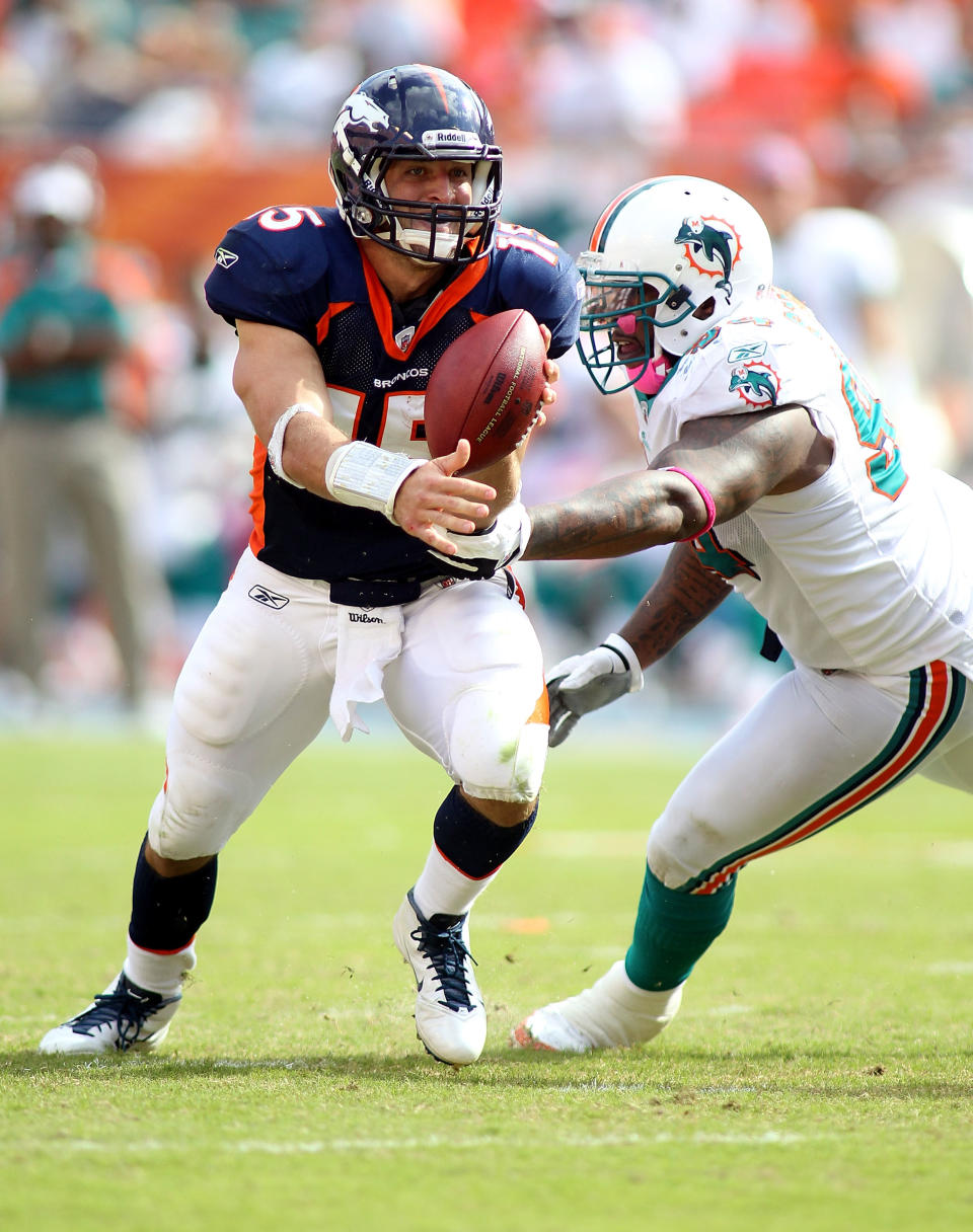 MIAMI GARDENS, FL - OCTOBER 23: Quarterback Tim Teebow #15 of the Denver Broncos rolls out against Cameron Wake #91 of the Miami Dolphins to end the game to overtime at Sun Life Stadium on October 23, 2011 in Miami Gardens, Florida. Denver defeated Miami 18-15. (Photo by Marc Serota/Getty Images)