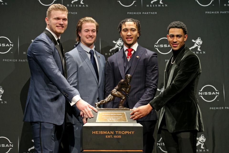 Heisman candidates (left to right): defensive end Aidan Hutchinson (Michigan), quarterback Kenny Pickett (Pittsburgh), quarterback C.J. Stroud (Ohio State) and quarterback Bryce Young (Alabama) pose for pictures with the Heisman Trophy during a news conference Dec. 11, 2021 in New York. Young was later named the winner.