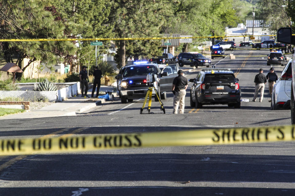 Image: Investigators work along a residential street following a deadly shooting on May 15, 2023, in Farmington, N.M.  (Susan Montoya Bryan / AP)