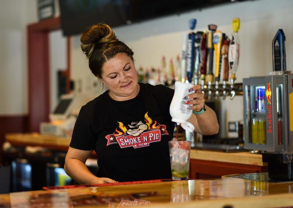 Smoke 'n Pig BBQ co-owner Kerissah Ries makes a mojito Wednesday, Aug. 9, 2023, in the new bar addition of the BBQ restaurant in Lansing.