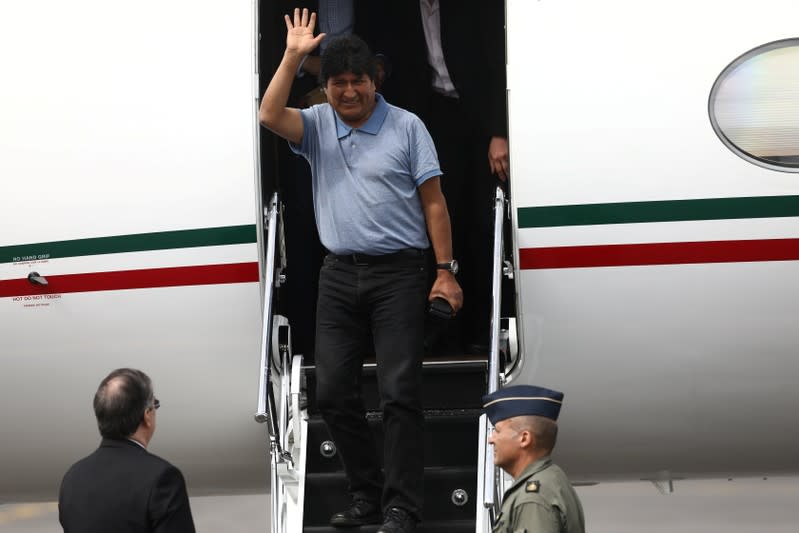 Bolivia's ousted President Evo Morales waves during his arrival to take asylum in Mexico, in Mexico City