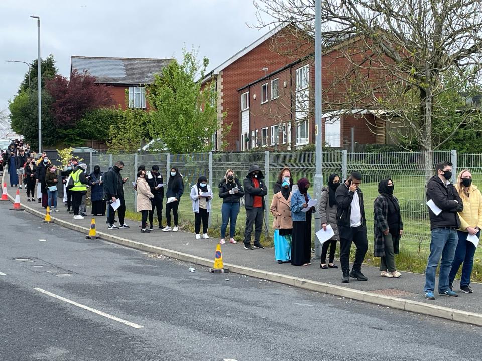 <p>People queue for the vaccination centre at the Essa Academy in Bolton, where the Indian variant has been detected</p> (PA)