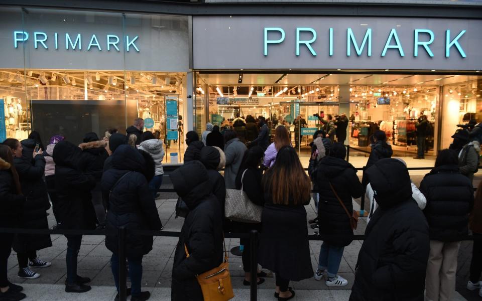Early morning shoppers stand in line outside Primark, Birmingham, waiting for the store to reopen as England takes another step back towards normality with the further easing of lockdown restrictions - Jacob King 