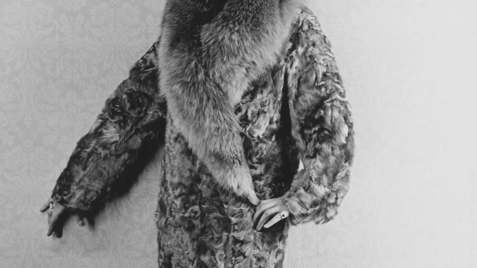 woman modeling lamb coat trimmed with fox