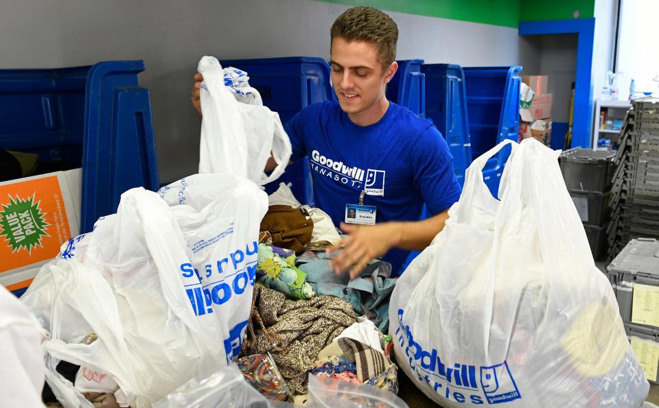 Brandon Sweeney, 22, works a second job at Goodwill. One of his main jobs is sorting the donations.