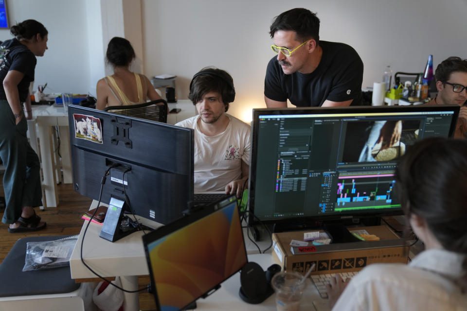 Chris Langer, top right, co-founder of CMYK, a digital design agency, speaks with an staff member at their office in New York, Tuesday, June 25, 2024. Last year, Langer started hearing chatter about the four-day work week, so he decided to try it out during the summer. (AP Photo/Seth Wenig)