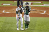 Oakland Athletics starting pitcher Paul Blackburn and catcher Sean Murphy talk as they walk back to the mound in the first inning of a baseball game against the Texas Rangers, Wednesday, July 13, 2022, in Arlington, Texas. (AP Photo/Tony Gutierrez)