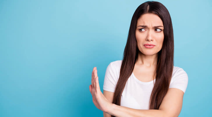 a woman who is frowning and placing her arm up to her side, suggest pushing something away