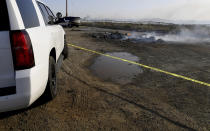 Sheriff's tape surrounds a smoldering pile on 7th Street as firefighters battle the Sandalwood Fire in Calimesa, Calif., on Thursday, Oct. 10, 2019. The blaze, dubbed the Sandalwood Fire, was one of several that broke out amid high winds and dry conditions that prompted California utilities to preemptively cut power to more than 2 million people in high-danger areas to guard against power lines sparking fires. (Jennifer Cappuccio Maher/The Orange County Register/SCNG via AP)