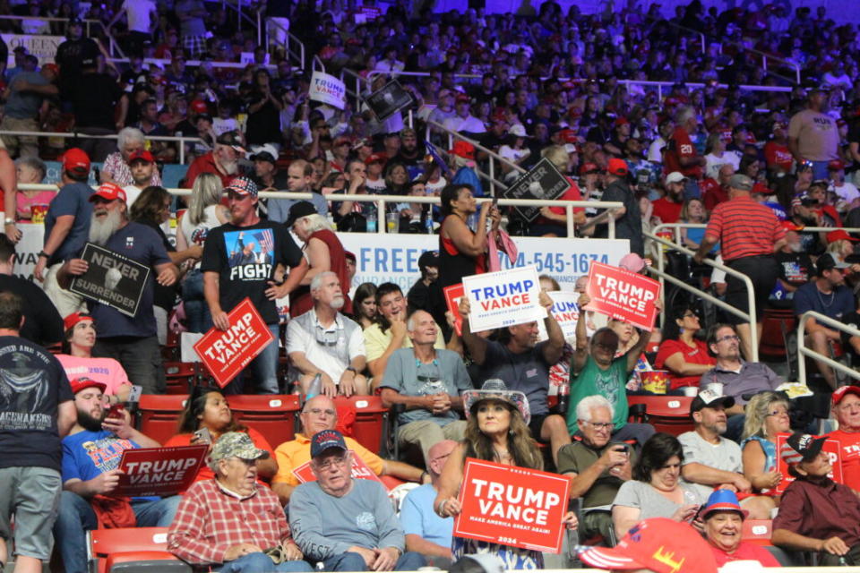 Supporters of former President Donald Trump hold up signs