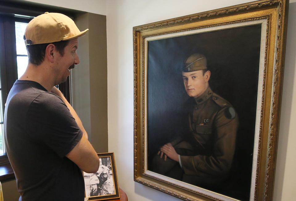 Micah Kraus of Akron admires a portrait of John S. Knight at the Summit County Land Bank's new offices at the former home of John S. Knight in Akron on Friday.