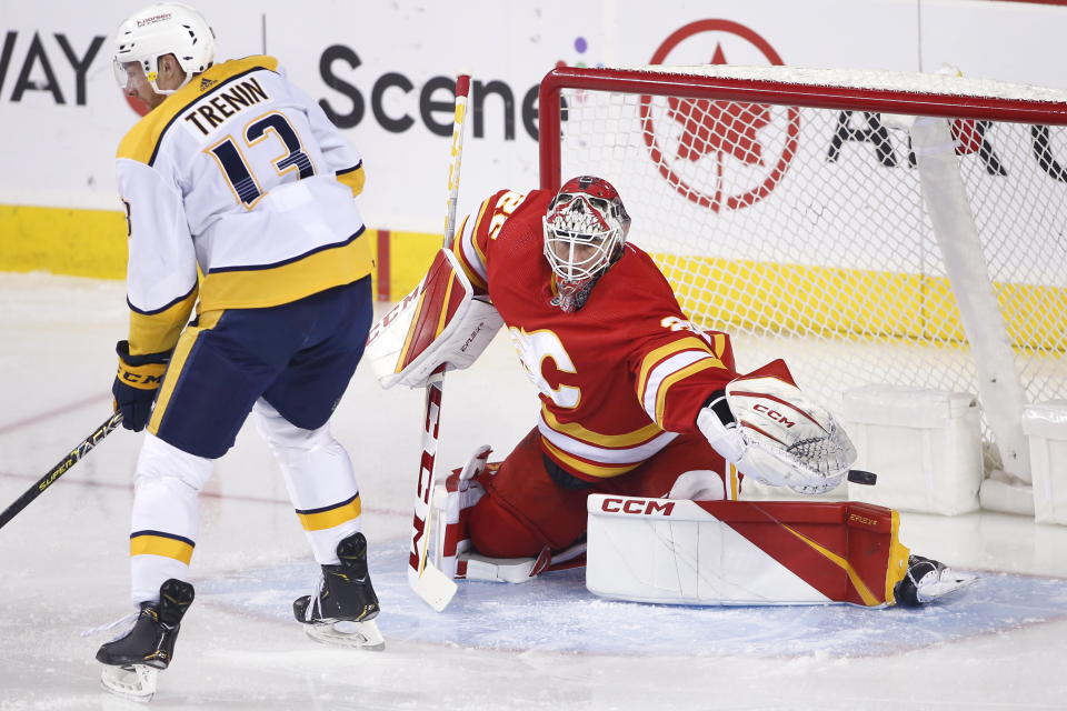 Nashville Predators' Yakov Trenin, left, tries to screen a shot as Calgary Flames goalie Jacob Markstrom makes a save during first-period NHL hockey game action in Calgary, Alberta, Thursday, Nov. 3, 2022. (Larry MacDougal/The Canadian Press via AP)