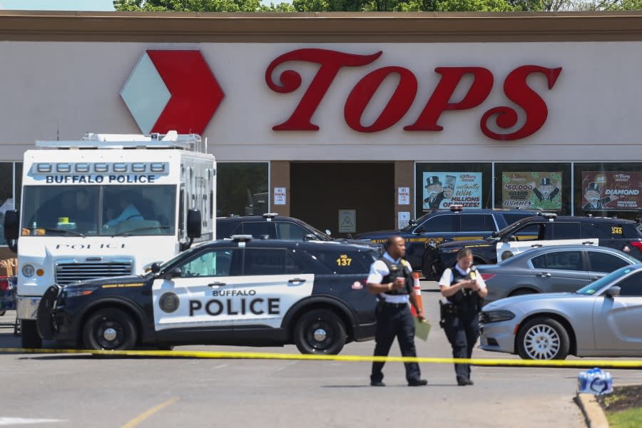 Police walk outside the Tops grocery store on Sunday, May 15, 2022, in Buffalo, N.Y. A white 18-year-old wearing military gear and livestreaming with a helmet camera opened fire with a rifle at the supermarket, killing and wounding people in what authorities described as “racially motivated violent extremism.” (AP Photo/Joshua Bessex)