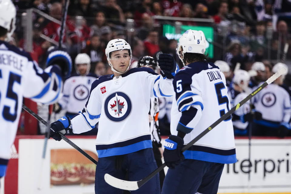 Winnipeg Jets' Neal Pionk, center, celebrates with teammates after scoring a goal against the New Jersey Devils during the first period of an NHL hockey game Sunday, Feb. 19, 2023, in Newark, N.J. (AP Photo/Frank Franklin II)