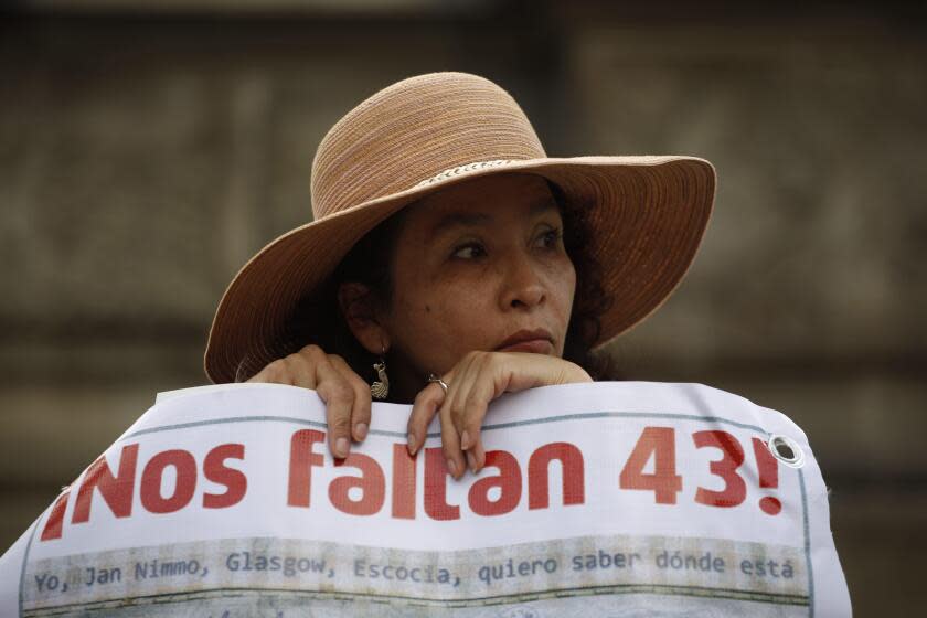 FILE - A woman carries a banner that reads in Spanish &quot;We are missing 43,&quot; referring to the 43 missing students from a rural teachers college during a march in Mexico City, Thursday, Nov. 26, 2015. The Truth Commission created to find out what happened to the missing students presented on Thursday, Aug. 18, 2022, a report that hints at the possible responsibility of the Mexican army in the disappearance. (AP Photo/Eduardo Verdugo, File)
