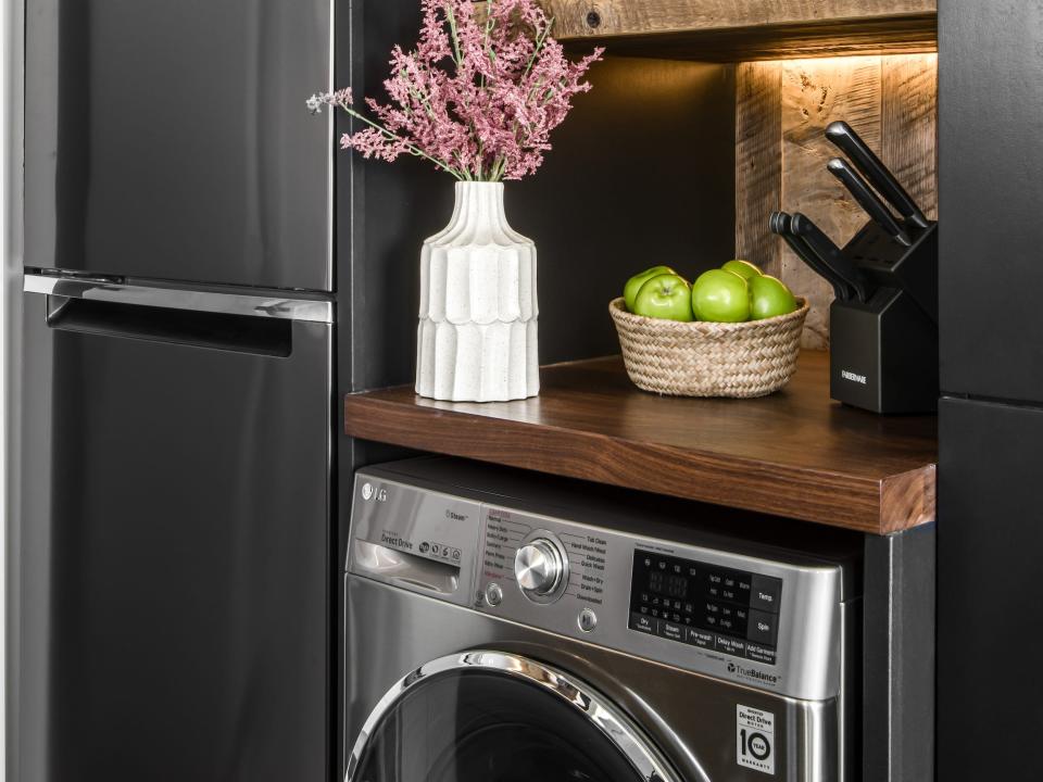 a dishwasher under shelves and a fridge