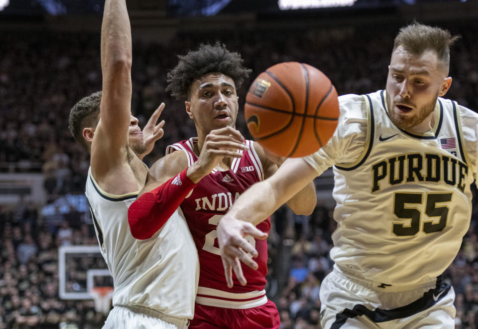 Indiana forward Trayce Jackson-Davis, center, loses control of the ball while being defended by Purdue guard Sasha Stefanovic (55) and forward Mason Gillis during the first half of an NCAA college basketball game, Saturday, March 5, 2022, in West Lafayette, Ind. (AP Photo/Doug McSchooler)