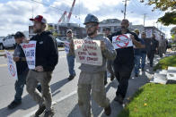 Justin Paetow, center, a tin shop worker at Bath Iron Works, takes part in a demonstration against COVID-19 vaccine mandate outside the shipyard on Friday, Oct. 22, 2021, in Bath, Maine. Some American workers are making the painful decision to quit their jobs and abandon cherished careers in defiance of what they consider intrusive vaccine mandates requiring all businesses with 100 or more workers be fully vaccinated against COVID-19. (AP Photo/Josh Reynolds)