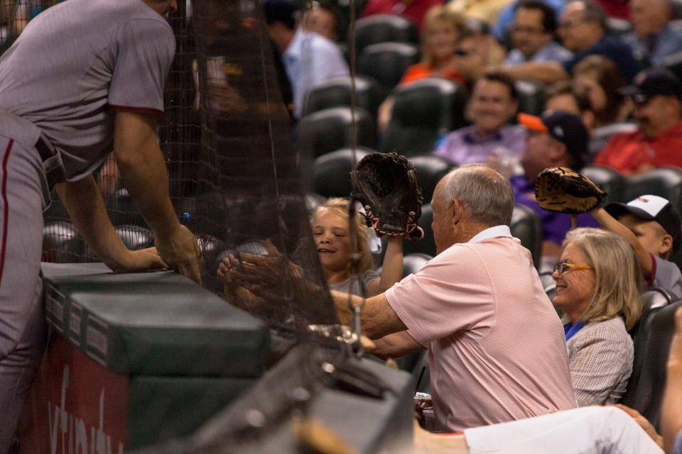 APRIL 29 2014: Former Houston Astros pitcher Nolan Ryan reaches underneath the net to retrieve a foul ball for a young fan during the game against the Washington Nationals. Washington Nationals defeated Houston Astros 4-3 at Minute Maid Park in Houston, TX. (Photo by Juan DeLeon/Icon SMI/Corbis via Getty Images)