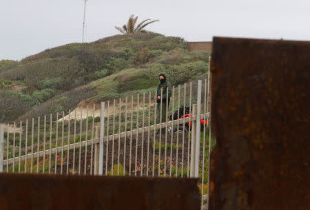 A U.S. Border Patrol agent is seen through the border fence between the United States and Mexico as photographed from Tijuana, Mexico February 11, 2017. REUTERS/Jorge Duenes