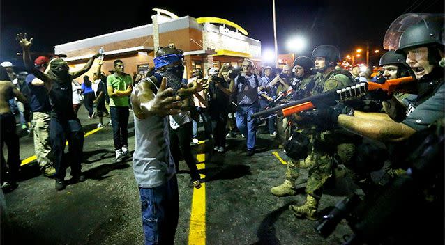Police officers move in to arrest protesters as they push and clear crowds out of the West Florissant Avenue area in Ferguson. Photo: AP