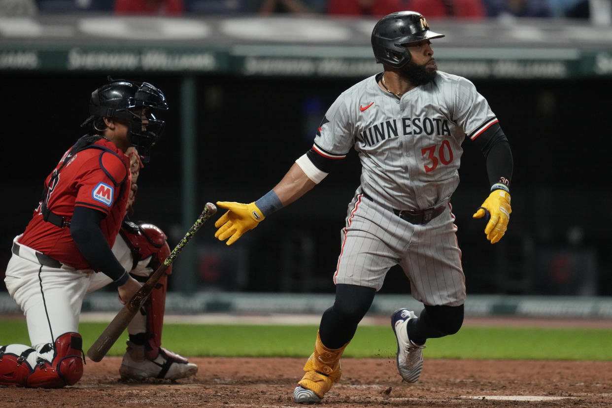 Minnesota Twins' Carlos Santana (30) watches his single with Cleveland Guardians catcher Bo Naylor, left, in the sixth inning of a baseball game Monday, Sept. 16, 2024, in Cleveland. (AP Photo/Sue Ogrocki)