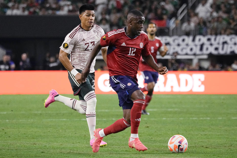 Costa Rica forward Joel Campbell (12) controls the ball in front of Mexico defender Jesús Gallardo (23) during the first half of a CONCACAF Gold Cup soccer quarterfinal Saturday, July 8, 2023, in Arlington, Texas. (AP Photo/Sam Hodde)