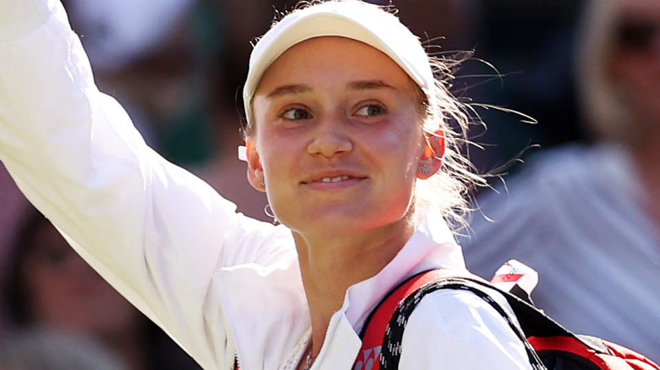 Elena Rybakina waves to the Wimbledon crowd as she walks off the court.