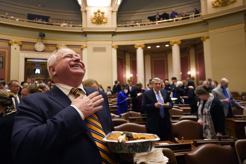 Gov. Tim Walz laughs while delivering pumpkin bars to members of the house before the first day of the 2023 legislative session, Tuesday, Jan. 3, 2023, in St. Paul, Minn. (AP Photo/Abbie Parr)