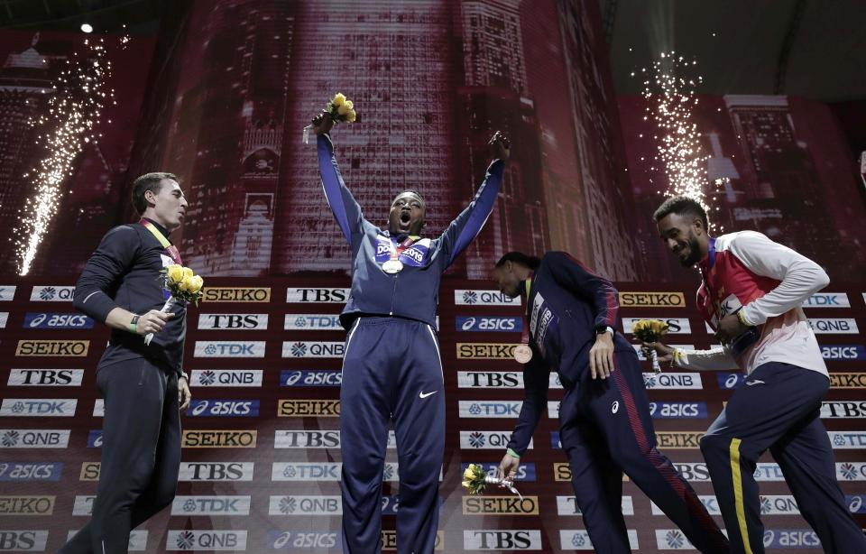 Gold medalist Grant Holloway, of the United States, raises his arms during the award ceremony for the men's 110 meter hurdles at the World Athletics Championships in Doha, Qatar, Thursday, Oct. 3, 2019. From left are silver medalist Sergey Shubenkov, who participates as a neutral athlete, Holloway, joint bronze medalists Pascal Martinot-Lagarde of France and Orlando Ortega, of Spain. (AP Photo/Nariman El-Mofty)