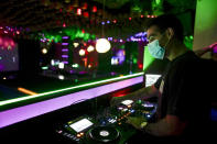 A DJ performs in a discotheque in Madrid, Spain, early Saturday, July 25, 2020. Nightlife is becoming the new target of Spanish authorities attempting to contain a spike in coronavirus infections since the country ended a lockdown. The Catalonia regional government has shut nightlife venues in Barcelona, and on Friday officials in Madrid said they were considering a similar step. (AP Photo/Manu Fernandez)