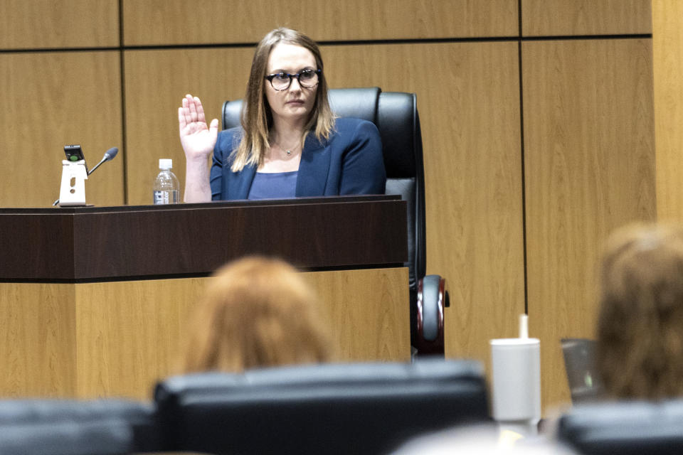Cobb County teacher Katie Rinderle is sworn in to testify during a hearing at the Cobb County Board of Education in Marietta, Ga, Thursday, Aug. 10, 2023. Rinderle is facing termination after reading "My Shadow is Purple," a book about gender identity, to fifth graders. (Arvin Temkar/Atlanta Journal-Constitution via AP)