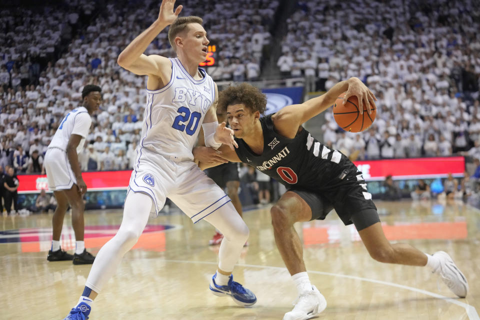 Cincinnati guard Dan Skillings Jr. (0) drives as BYU guard Spencer Johnson (20) defends during the first half of an NCAA college basketball Saturday, Jan. 6, 2024, in Provo, Utah. (AP Photo/Rick Bowmer)